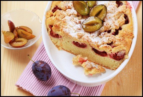 a plum cake decorated with sliced, fresh plums
